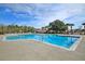 Expansive community pool featuring a splash area, palm trees, and ample deck space for residents to enjoy at 5073 Blair Rd, Summerville, SC 29483