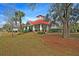 Charming pool pavilion with red roof, surrounded by lush landscaping, offering a relaxing space for gatherings at 5073 Blair Rd, Summerville, SC 29483