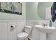 Powder room featuring a white pedestal sink, toilet and decorative accents at 5073 Blair Rd, Summerville, SC 29483