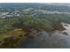 Aerial view shows the property bordering the marshlands, outlined in white, surrounded by lush trees and neighborhood at 509 Seven Farms Dr, Charleston, SC 29492
