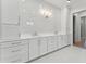Elegant bathroom featuring a dual sink vanity with white cabinets, marble backsplash and modern lighting at 509 Seven Farms Dr, Charleston, SC 29492