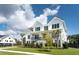 Elegant raised white home showcasing landscaped yard, black trim, and inviting staircase at 509 Seven Farms Dr, Charleston, SC 29492