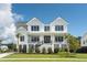 Stunning two-story white home featuring dual gables, elevated structure, and manicured front yard at 509 Seven Farms Dr, Charleston, SC 29492