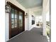 Inviting front porch featuring wooden floors, lantern lighting, and double doors at 509 Seven Farms Dr, Charleston, SC 29492