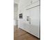 Close-up of the kitchen featuring custom white cabinets, built-in microwave, drawers, and stainless steel refrigerator at 509 Seven Farms Dr, Charleston, SC 29492