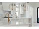 Gourmet kitchen boasts pendant lighting, white cabinetry, and a tile backsplash at 509 Seven Farms Dr, Charleston, SC 29492