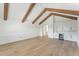 Open living room featuring exposed beams, hardwood floors, wainscotting, and a wet bar area at 509 Seven Farms Dr, Charleston, SC 29492