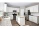 Bright kitchen boasts white cabinets, stainless steel appliances, granite countertops, and a convenient center island at 548 Richfield Way, Summerville, SC 29486