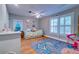 Bright bedroom with white trim, light hardwood floors, a ceiling fan and colorful decorations throughout at 731 Fort Johnson Rd, Charleston, SC 29412