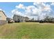 Large backyard with green lawn, backing up to neighboring homes and featuring a utility trailer at 7753 Kinston St, North Charleston, SC 29418