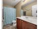 Cozy bathroom with tile floors, wood vanity, decorative mermaid, and shower-tub combo with blue curtain at 7753 Kinston St, North Charleston, SC 29418