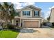 Two-story home with tan siding, attached garage, manicured lawn, and welcoming curb appeal at 7753 Kinston St, North Charleston, SC 29418