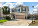 Charming two-story home featuring tan siding, green shutters, and an attached two-car garage at 7753 Kinston St, North Charleston, SC 29418