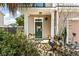 Inviting front porch with a green door, decorative wreath, and lush landscaping at 7753 Kinston St, North Charleston, SC 29418
