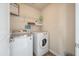 Functional laundry room with modern washer and dryer, shelving for storage, and tile flooring at 7753 Kinston St, North Charleston, SC 29418