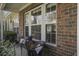 Charming brick front porch with cozy seating area and views of the surrounding landscape at 901 Elm Hall Cir, Summerville, SC 29483