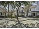 Street view of well-maintained townhomes with mature trees, manicured shrubs, and designated parking spots at 901 Elm Hall Cir, Summerville, SC 29483