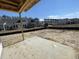 Backyard of a new home construction with a concrete patio and graded soil at 909 Dusk Dr, Summerville, SC 29486