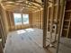 Bedroom under construction with wood framing, sheathing, and two bright windows at 909 Dusk Dr, Summerville, SC 29486