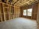 Spacious bedroom under construction with wood framing, large windows and a concrete floor at 909 Dusk Dr, Summerville, SC 29486