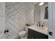 Stylish half-bathroom with patterned wallpaper, black fixtures, and a modern vanity at , Charleston, SC 29412