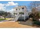 Charming two-story home with white exterior, double porches, palm trees, and landscaped yard at , Charleston, SC 29412