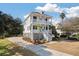 Charming two-story home with white exterior, double porches, palm trees, and landscaped yard at , Charleston, SC 29412