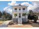 Charming two-story home with white exterior, double porches, palm trees, and landscaped yard at , Charleston, SC 29412
