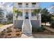 A charming front entrance with elegant black door, flanked by stylish planters and black framed windows at , Charleston, SC 29412