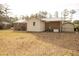 Backyard featuring a home, outbuilding, and whole house generator set against mature trees at 105 Pinewood St, Walterboro, SC 29488
