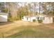 Backyard featuring multiple outbuildings with neutral paint, set against mature trees at 105 Pinewood St, Walterboro, SC 29488