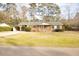 Charming brick home featuring a metal roof, carport, and spacious front yard at 105 Pinewood St, Walterboro, SC 29488