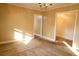 Cozy living room featuring neutral walls, carpet flooring, a vintage chandelier, and ample natural light at 105 Pinewood St, Walterboro, SC 29488