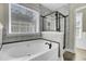 Bright bathroom features a luxurious soaking tub with black hardware and a glass-enclosed shower at 110 Instructor Ct, Ladson, SC 29456
