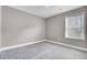 An empty bedroom with gray walls, neutral carpet, and one window at 110 Instructor Ct, Ladson, SC 29456
