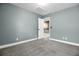 An empty bedroom with light blue walls, neutral carpet, one window, and an open door to the hallway at 110 Instructor Ct, Ladson, SC 29456