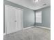 An empty bedroom with light blue walls, neutral carpet, one window, and a closet with double doors at 110 Instructor Ct, Ladson, SC 29456