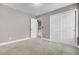 An empty bedroom with gray walls, neutral carpet, and a door leading to the hallway at 110 Instructor Ct, Ladson, SC 29456