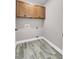 The laundry room features wood-look floors, built in cabinets, and neutral paint at 110 Instructor Ct, Ladson, SC 29456