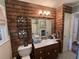 Bathroom featuring a toilet, vanity, sink, rustic-look accent wall, and mosaic floor tiles at 111 Newington Rd, Summerville, SC 29485