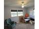 Bedroom with a ceiling fan, two windows, and a green armchair, offering a calm and airy atmosphere at 111 Newington Rd, Summerville, SC 29485