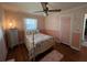 Cozy bedroom features a ceiling fan, wood floors, floral bedding, and a charming, cottage-style aesthetic at 111 Newington Rd, Summerville, SC 29485