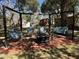 Outdoor fire pit area with multiple swing seats for relaxation and outdoor entertainment under mature trees at 111 Newington Rd, Summerville, SC 29485