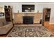 A cozy living room features a stone fireplace and wood floors with large area rug at 111 Newington Rd, Summerville, SC 29485