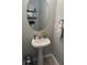 Stylish half bathroom featuring a pedestal sink, an oval mirror, and decorative wall shelves at 120 Hornby Cir, Goose Creek, SC 29445
