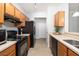 Kitchen with wooden cabinets and black appliances at 1225 Blakeway St # 403, Charleston, SC 29492