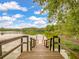 Scenic view of a wooden dock leading to a tranquil lake surrounded by lush greenery and trees at 127 Country Gate Ln, Summerville, SC 29485