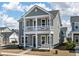 Two-story home featuring a gray exterior with white columns supporting the front porch and balcony at 127 Country Gate Ln, Summerville, SC 29485
