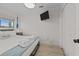 Cozy bedroom with light wood floors, window, and mounted tv at 1300 Ocean Blvd # 238, Isle of Palms, SC 29451
