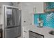 Well-lit kitchen featuring stainless steel appliances, blue backsplash, and modern cabinetry at 1300 Ocean Blvd # 238, Isle of Palms, SC 29451